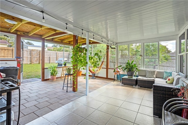 sunroom featuring lofted ceiling and wooden ceiling