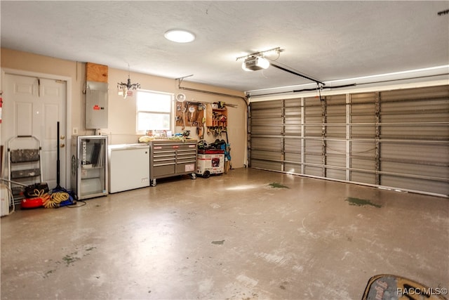 garage featuring white refrigerator, a garage door opener, and electric panel