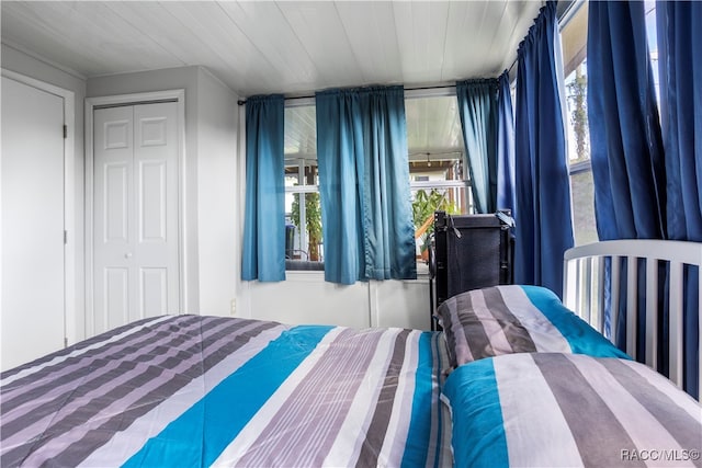 bedroom featuring wooden ceiling and a closet