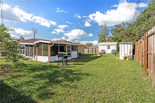 view of yard featuring a sunroom and a storage shed