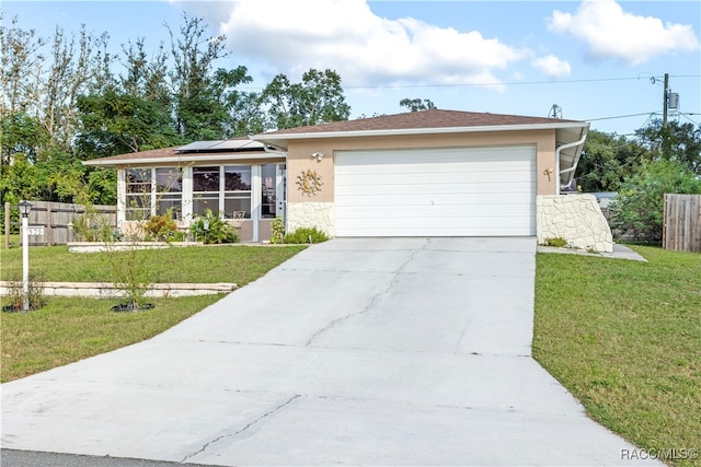 single story home with solar panels, a garage, and a front lawn