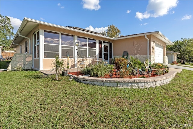 rear view of house featuring a yard, a garage, and solar panels