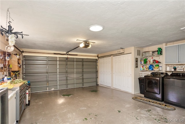 garage with separate washer and dryer and a garage door opener