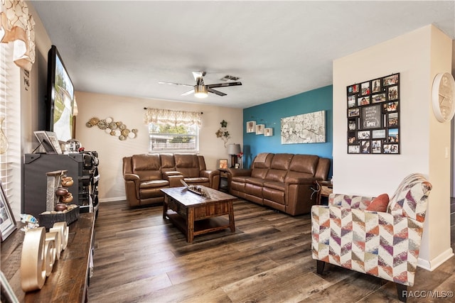 living room featuring ceiling fan and dark hardwood / wood-style floors