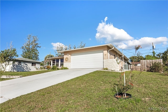 view of front of property with central AC unit, a garage, and a front lawn