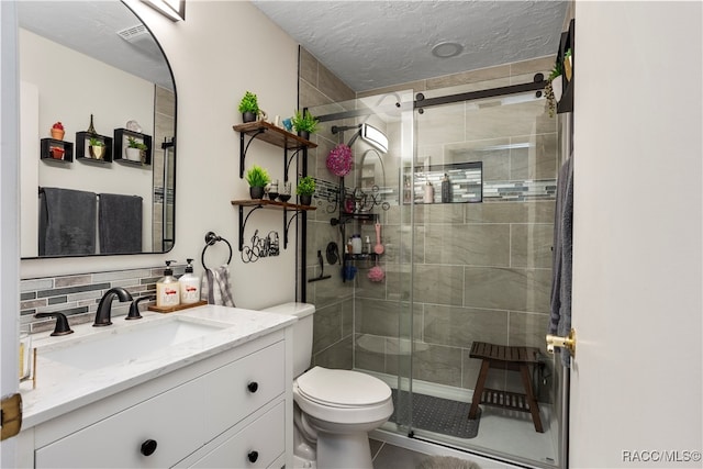 bathroom with backsplash, a textured ceiling, vanity, a shower with door, and toilet