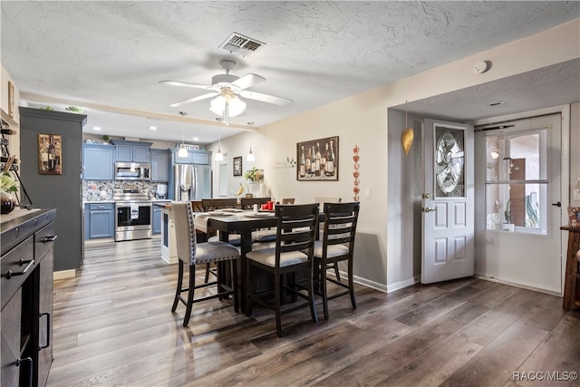 dining room featuring a textured ceiling, ceiling fan, and dark hardwood / wood-style floors