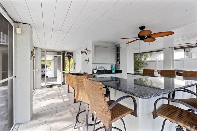 sunroom featuring ceiling fan and wooden ceiling