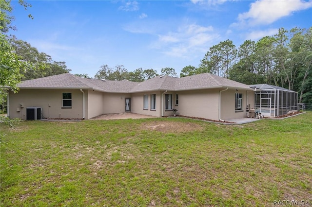 back of property with cooling unit, a patio, glass enclosure, and a lawn