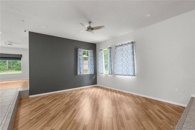 unfurnished room featuring ceiling fan, plenty of natural light, and light hardwood / wood-style flooring