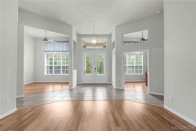 entrance foyer with french doors, ceiling fan, tile patterned floors, and plenty of natural light