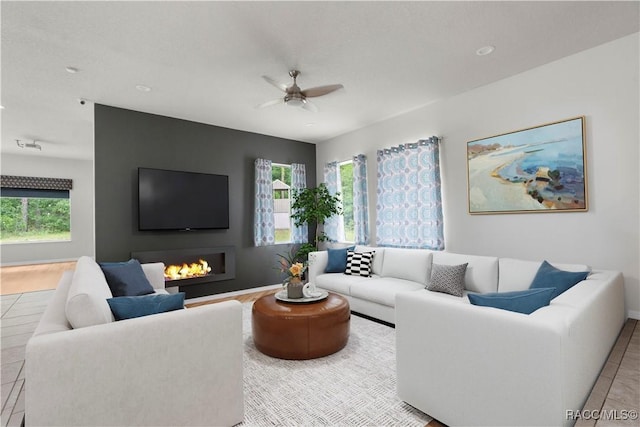 living room with ceiling fan, a healthy amount of sunlight, and light tile patterned floors