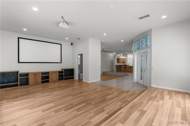 cinema room featuring ceiling fan, light wood-type flooring, and french doors