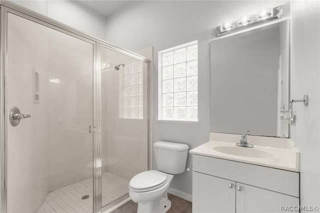 bathroom featuring a shower with door, vanity, and toilet