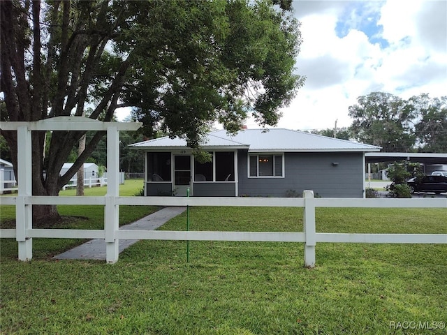 back of house featuring a sunroom and a lawn