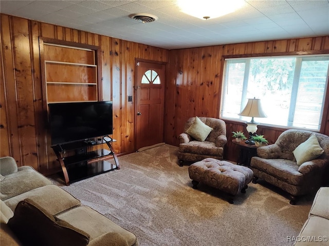 carpeted living room with wooden walls