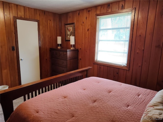 carpeted bedroom featuring wood walls