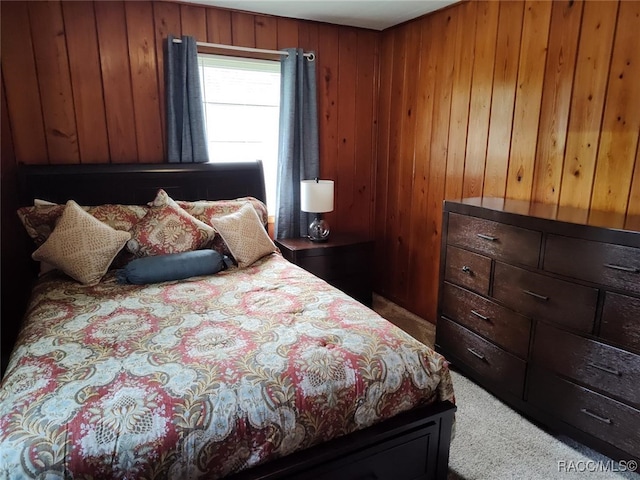 carpeted bedroom featuring wood walls