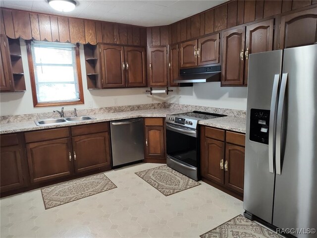 kitchen featuring light tile patterned flooring, sink, dark brown cabinetry, and stainless steel appliances