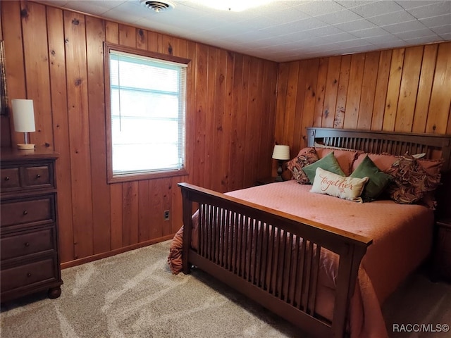 carpeted bedroom with wood walls