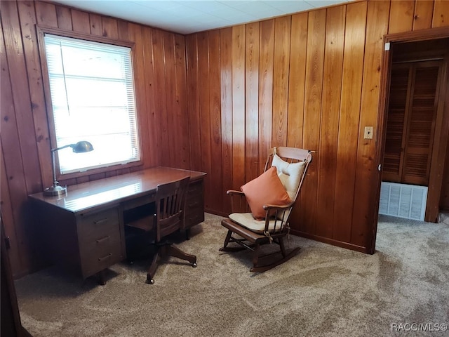 home office with light carpet and wood walls