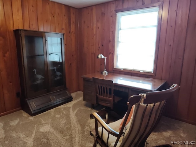 office area featuring wood walls and light carpet