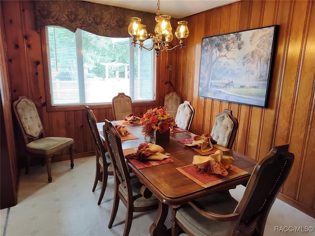 dining space featuring wooden walls and a notable chandelier