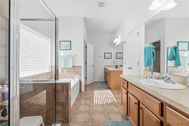 bathroom with tile patterned flooring, vanity, and plus walk in shower