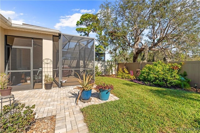 view of yard featuring glass enclosure and a patio area