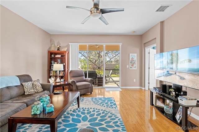 living room with light hardwood / wood-style flooring and ceiling fan