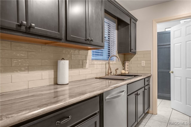 kitchen featuring light tile patterned floors, backsplash, dark brown cabinets, and sink