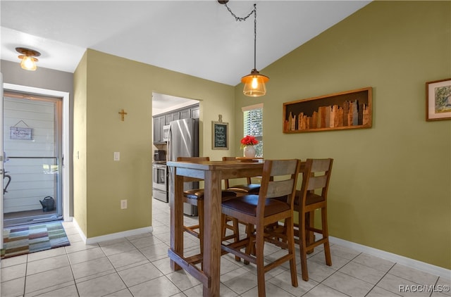 tiled dining room with vaulted ceiling