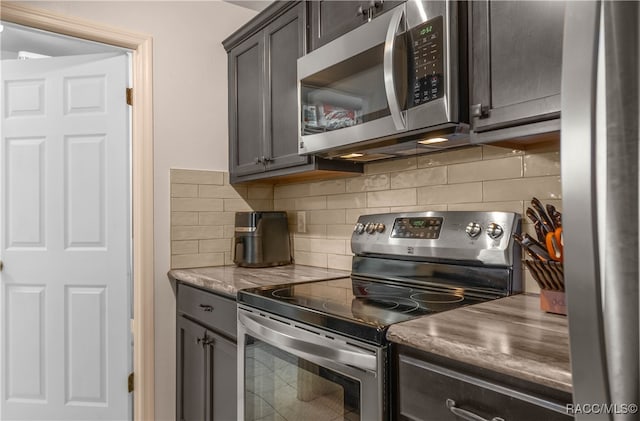 kitchen featuring decorative backsplash, dark brown cabinets, and stainless steel appliances