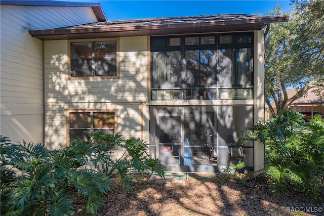 rear view of property with a sunroom