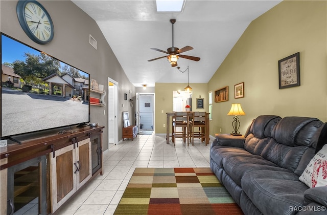 tiled living room with ceiling fan and high vaulted ceiling