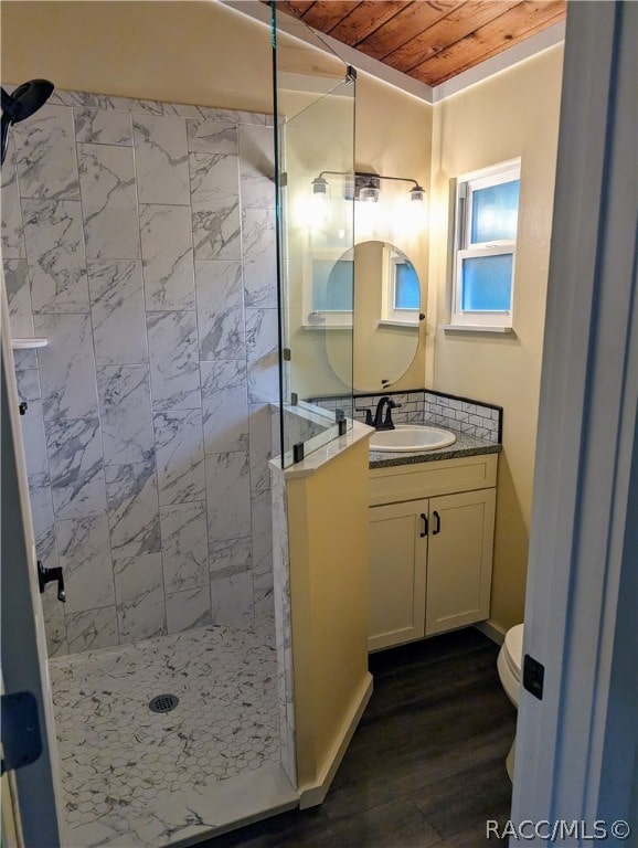 bathroom with tiled shower, vanity, wood ceiling, and wood-type flooring