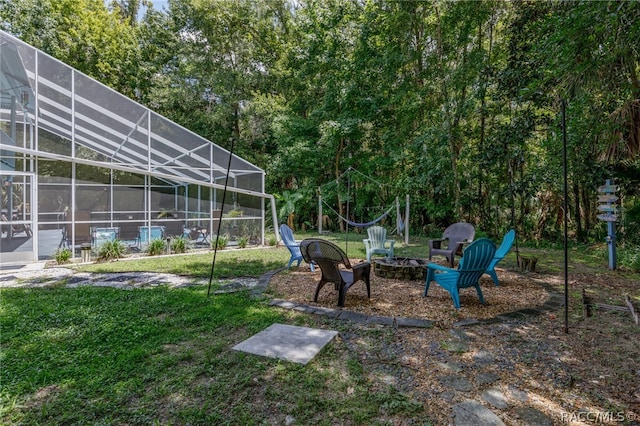 view of yard featuring a fire pit and glass enclosure