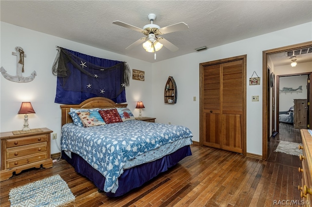 bedroom with a textured ceiling, ceiling fan, a closet, and dark hardwood / wood-style floors