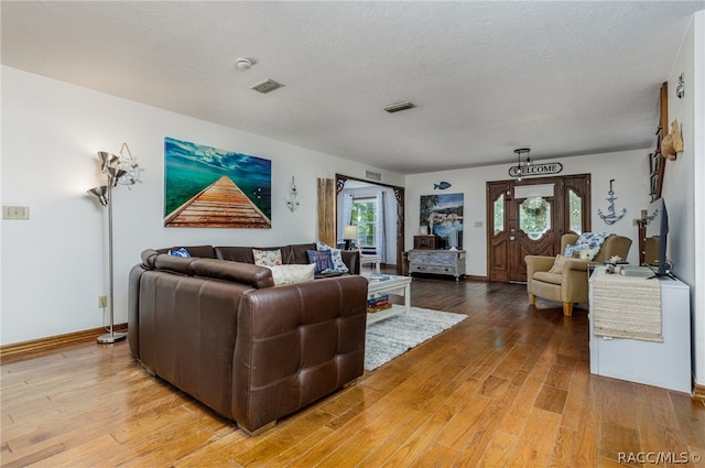 living room with wood-type flooring and a textured ceiling