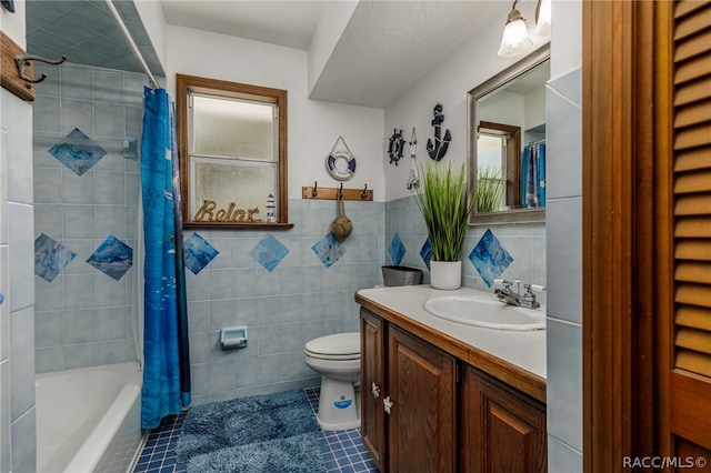 full bathroom featuring vanity, shower / bathtub combination with curtain, toilet, and tile walls