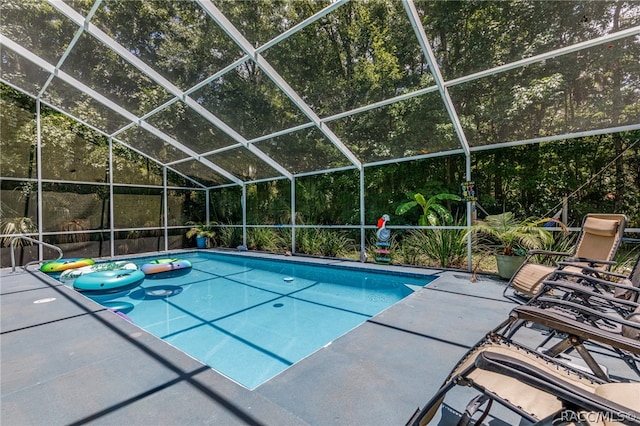 view of pool featuring a patio and glass enclosure