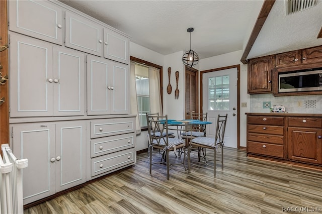 dining space featuring a textured ceiling and light hardwood / wood-style flooring