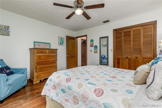 bedroom with a textured ceiling, a closet, hardwood / wood-style flooring, and ceiling fan