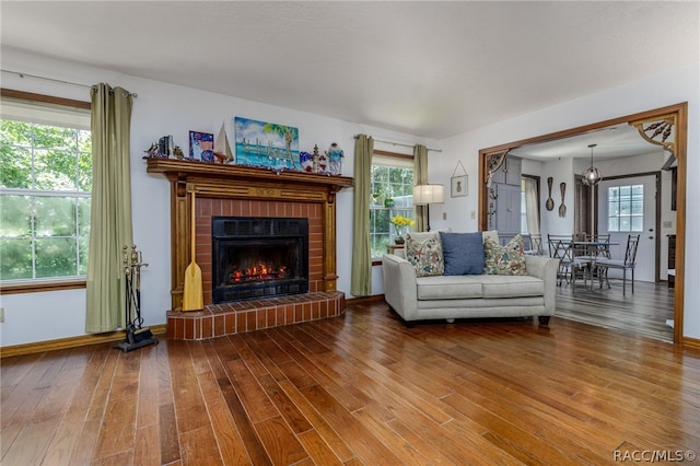 living room with hardwood / wood-style floors and a brick fireplace