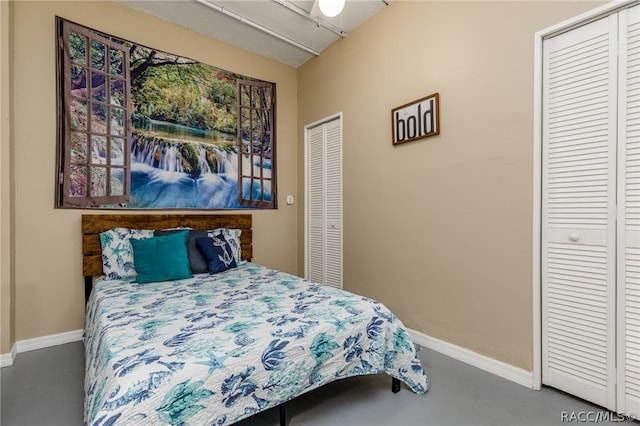 bedroom featuring multiple closets and concrete floors