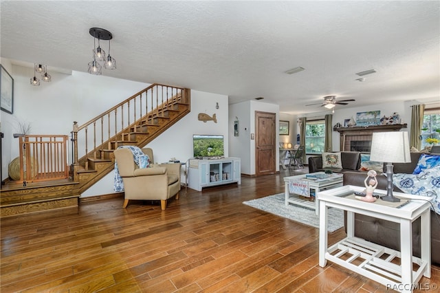 living room with hardwood / wood-style floors, ceiling fan, a healthy amount of sunlight, and a textured ceiling