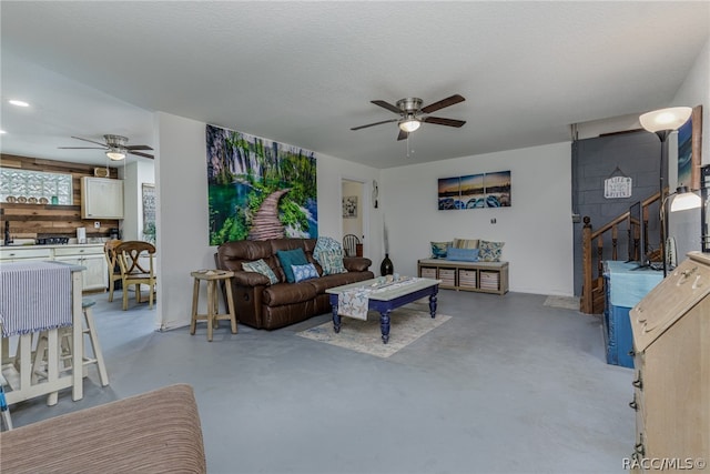 living room featuring a textured ceiling and ceiling fan