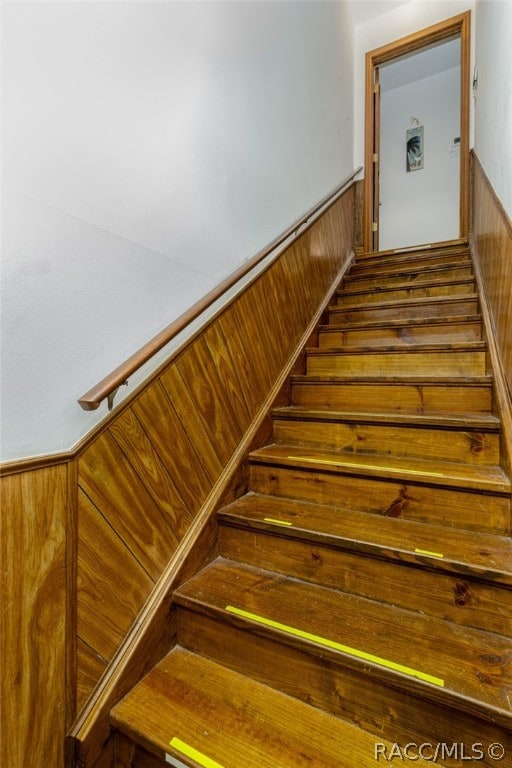 stairs featuring wooden walls