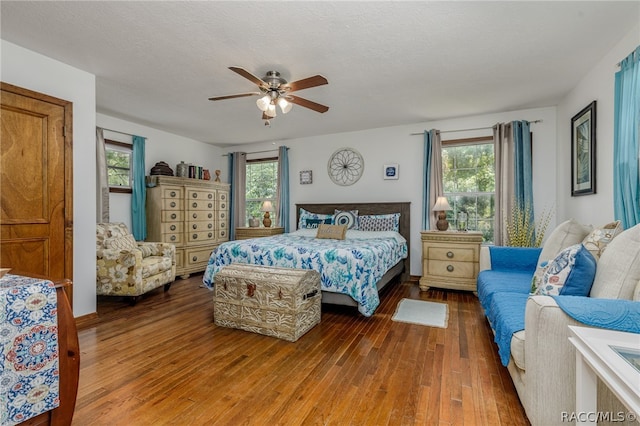 bedroom featuring multiple windows, ceiling fan, a textured ceiling, and hardwood / wood-style flooring