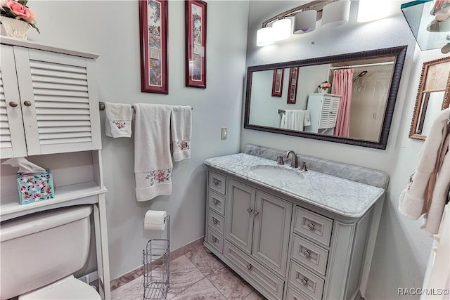 bathroom with toilet, a shower with shower curtain, vanity, baseboards, and marble finish floor